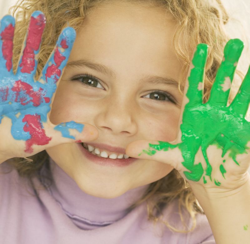 Smiling Girl with Hands Covered in Paint