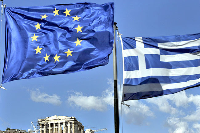 (FILES) In this file picture taken on May 10, 2011 the European Union (L) and the Greek flags fly above the ancient temple of Parthenon atop the Acropolis hill in Athens. Rating agency S&P fired a warning shot over Greek debt on July 4, 2011, upsetting relief at a weekend deal, saying that proposals for a payment holiday under a new rescue could trigger partial default. S&P has lowered the long-term rating on Greek public debt to "CCC" from "B" and it said that a proposal floated by the French Bank Federation risked putting Greece into a selective default.  AFP PHOTO / ARIS MESSINIS