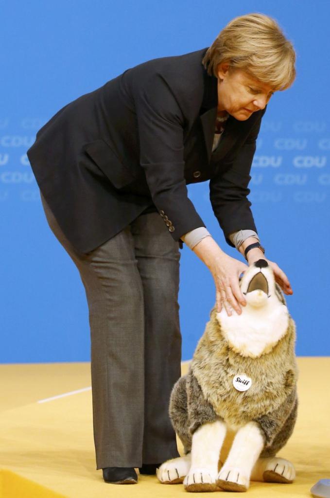 German Chancellor Angela Merkel and leader of the Christian Democratic Union (CDU) receives a gift of a Steiff soft toy dog during the CDU party congress in Karlsruhe, Germany December 14, 2015.   REUTERS/Kai Pfaffenbach