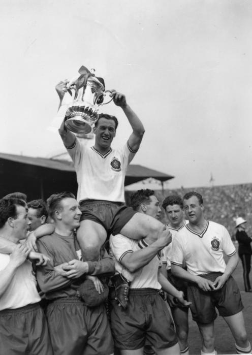 3rd May 1958:  Bolton Wanderers captain Nat Lofthouse sits on the shoulders of his team mates as he lifts the FA Cup trophy, after their 2-0 victory over Manchester United in the FA Cup final at Wembley Stadium.  (Photo by Ron Burton/Keystone/Getty Images)