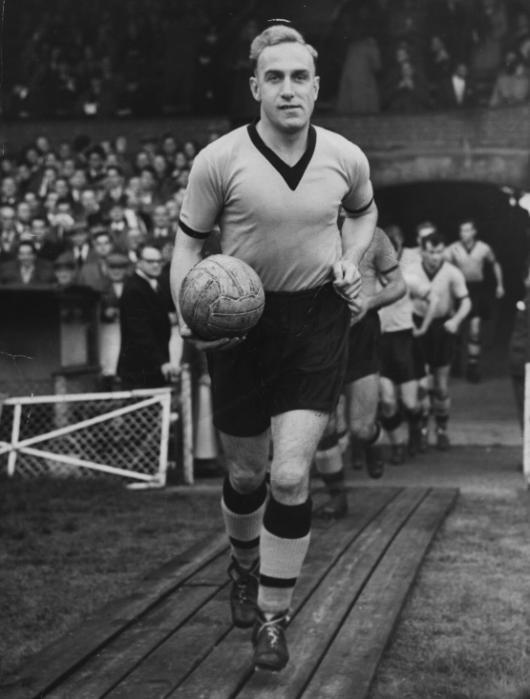 Billy Wright, the English footballer leading the Arsenal  team,  running from the tunnel up to the pitch.    (Photo by Hulton Archive/Getty Images)