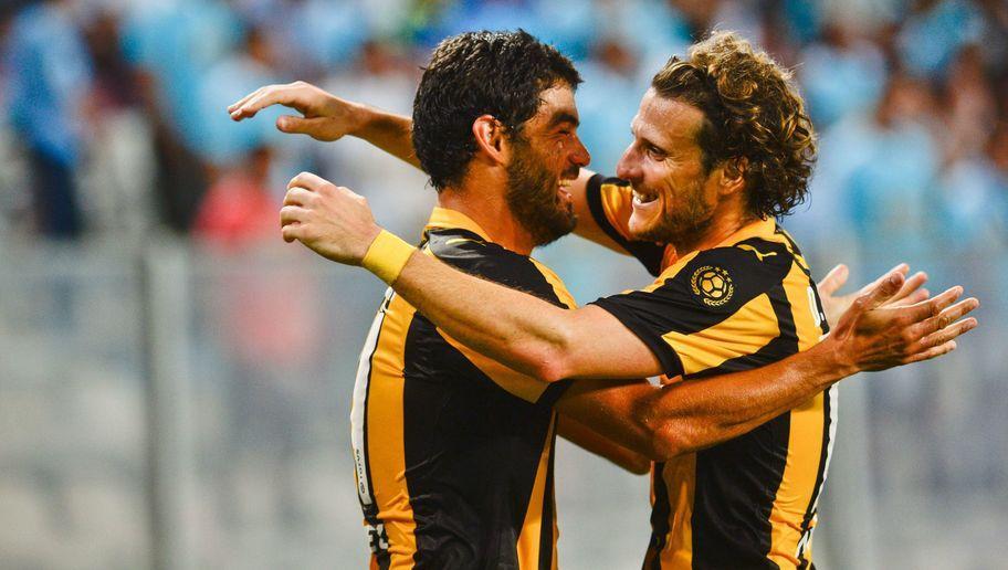 Luis Aguiar (L) of Uruguay's Penarol celebrates with teammate Diego Forlan after scoring against Peru's Sporting Cristal during their Copa Libertadores 2016 first round football match at the National Stadium in Lima on February 18, 2016. AFP PHOTO /ERNESTO BENAVIDES / AFP / ERNESTO BENAVIDES (Photo credit should read ERNESTO BENAVIDES/AFP/Getty Images)