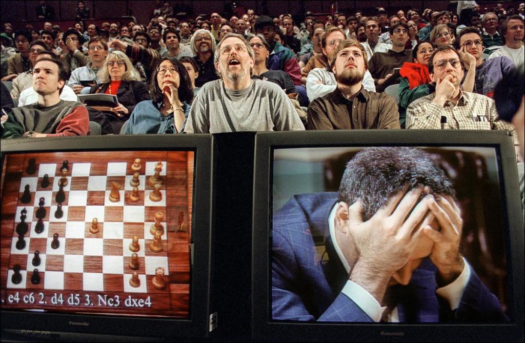 NEW YORK, UNITED STATES: Chess enthusiasts watch World Chess champion Garry Kasparov on a television monitor as he holds his head in his hands at the start of the sixth and final match 11 May 1997 against IBM's Deep Blue computer in New York. Kasparov lost this match in just 19 moves giving overall victory to Deep Blue with a score of 2.5-3.5. AFP PHOTO Stan HONDA (Photo credit should read STAN HONDA/AFP/Getty Images)