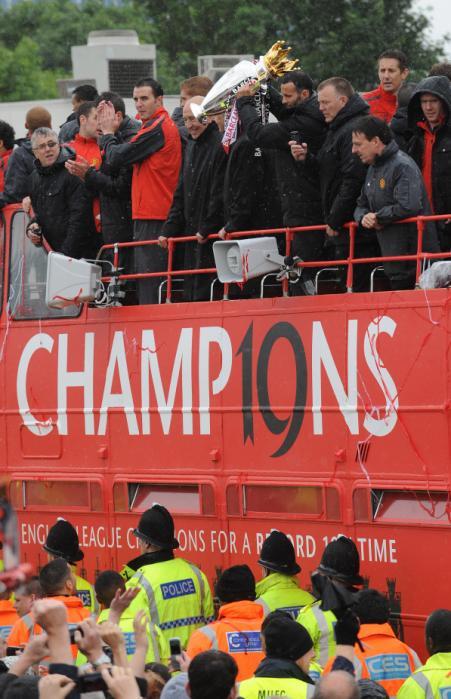 Manchester United's Ryan Giggs holds up the trophy as the Manchester United team make their way through the streets on an open top bus during the 2011 Barclays Premier League victory Parade past Old Trafford, Manchester.